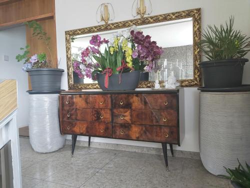a dresser with a mirror and some flowers on it at Penthouse in Schaan in Schaan
