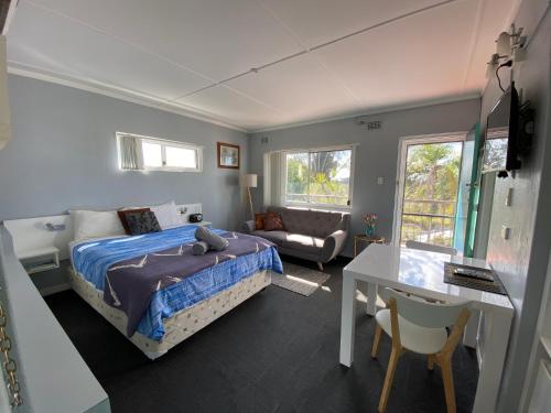 a bedroom with a bed and a table and a couch at Dukes Plantation Retro Motel in Tyndale