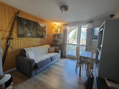 a living room with a couch and a table at Studio avec jardin et garage, à 100m d'une piste in Les Deux Alpes