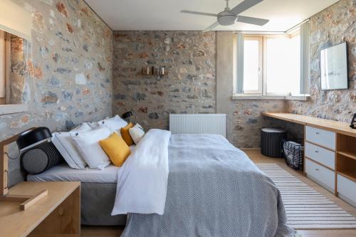 a bedroom with a bed and a stone wall at The Architect's Villa in Levktron