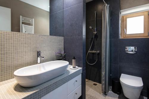 a bathroom with a white sink and a toilet at The Architect's Villa in Lévktron