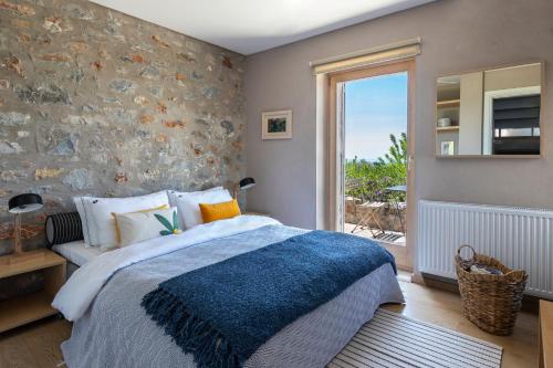 a bedroom with a bed and a stone wall at The Architect's Villa in Levktron