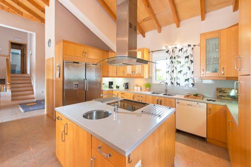 a kitchen with wooden cabinets and a stainless steel refrigerator at Olive Private Villa Swimming Pool 5 BDR Kolymbia Rhodes in Kolimbia
