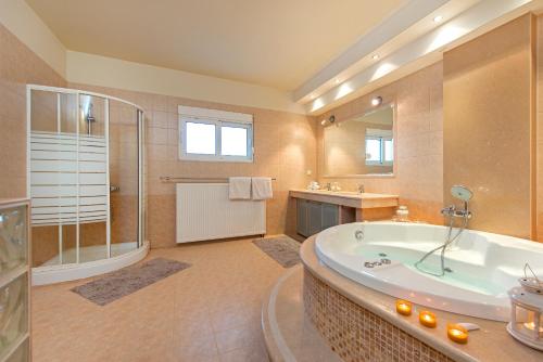a large bathroom with a tub and a shower at Olive Private Villa Swimming Pool 5 BDR Kolymbia Rhodes in Kolimbia