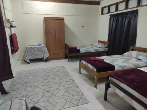 a room with two beds and two tables at CiTY Roomstay Budget Midtown Kuala Terengganu 2queen beds in Kuala Terengganu