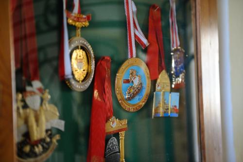 a group of medals are hanging on a wall at Hotel-Gasthof-Fleischerei - Zur alten Post in Schwanberg
