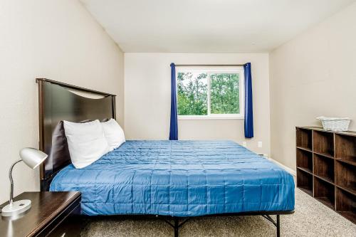 a bedroom with a bed with blue sheets and a window at Keyann Circle in Anchorage