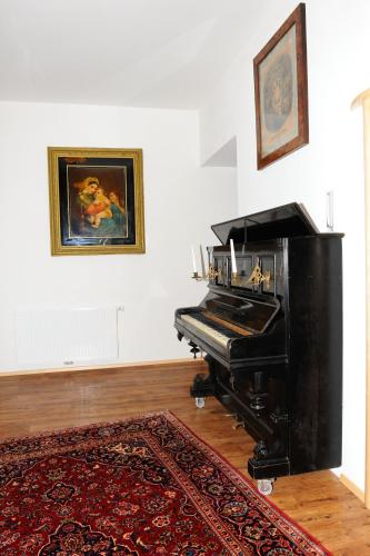 a black piano in a room with a rug at Hotel-Gasthof-Fleischerei - Zur alten Post in Schwanberg