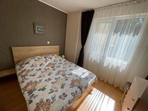 a bedroom with a bed with a quilt on it at Apartment George in Burgas