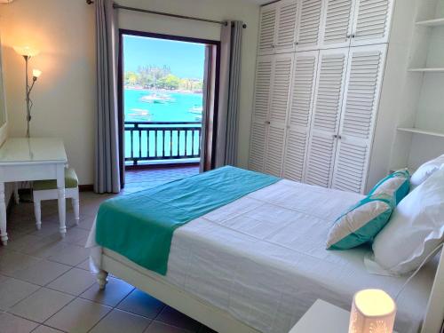 a bedroom with a bed and a view of the water at Grand Baie Beach Penthouse in Grand Baie