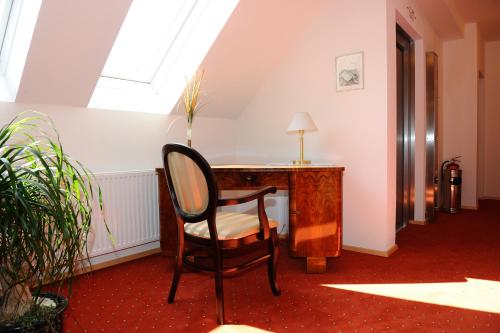 a chair in a room with a desk and a window at Hotel-Gasthof-Fleischerei - Zur alten Post in Schwanberg