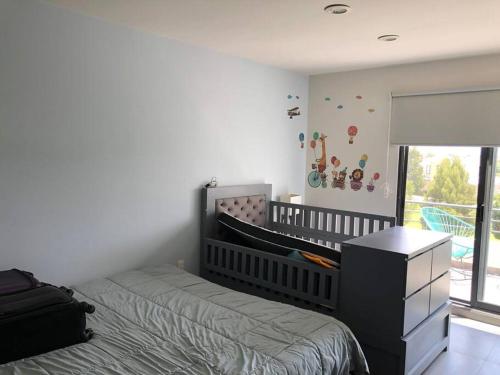 a baby room with a crib and a bed and a window at Beautiful 3BR townhouse with on-premises parking in Calimaya de Díaz González