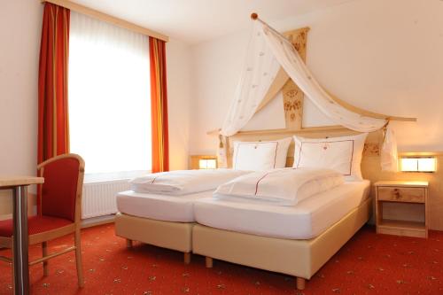 a bedroom with a large bed with a canopy at Hotel-Gasthof-Fleischerei - Zur alten Post in Schwanberg