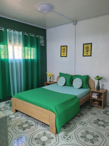 a bedroom with a green bed and green curtains at Residence Casablanca in Ambatoloaka