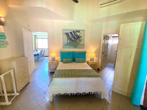 een slaapkamer met een groot bed met blauwe kussens bij Grand Baie Beach Penthouse in Grand Baie