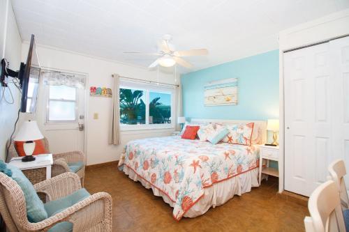 - une chambre avec un lit et un ventilateur de plafond dans l'établissement Tropic Terrace #31 - Beachfront Rental condo, à St. Pete Beach