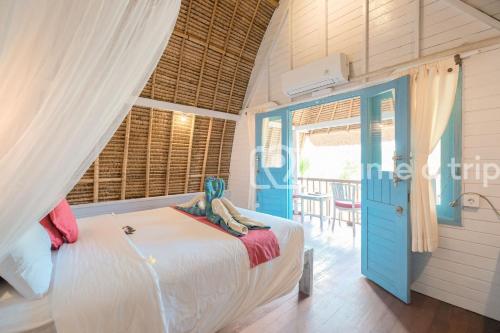 una habitación con una cama con una estatua sentada en ella en Dream Beach Kubu & SPA by ABM, en Nusa Lembongan