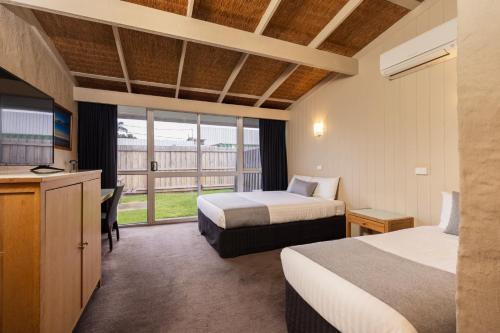 Habitación de hotel con 2 camas y balcón en Torquay Hotel/Motel, en Torquay