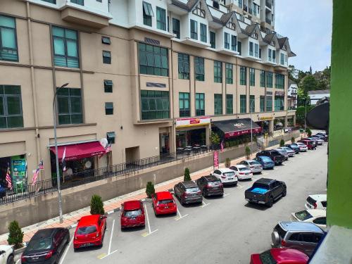 a parking lot with cars parked in front of a building at CH TRAVELLERS INN in Tanah Rata
