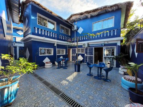 a blue house with blue stools in the courtyard at Residence Casablanca in Ambatoloaka