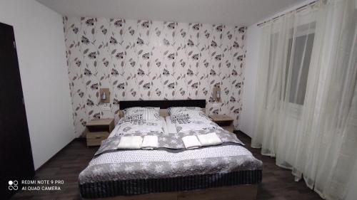 um quarto com uma cama com papel de parede floral em Lővér Vendégház Sopron em Sopron