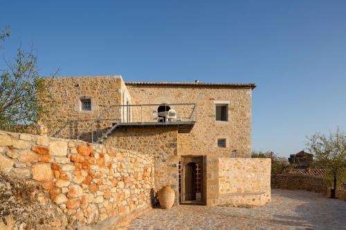 a stone building with a balcony on top of it at Casa Antica in Levktron