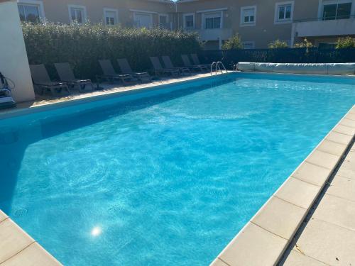 une grande piscine avec de l'eau bleue dans un immeuble dans l'établissement Appartement entre lac et mer avec piscine, à Péret