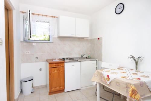 a small kitchen with a table and a sink at Apartments by the sea Valun, Cres - 8081 in Valun