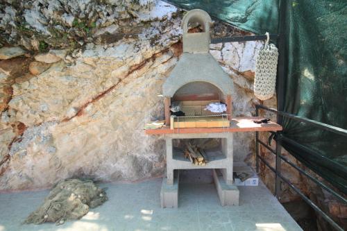 a stone wall with a pizza oven in front of it at Apartments by the sea Valun, Cres - 8086 in Valun