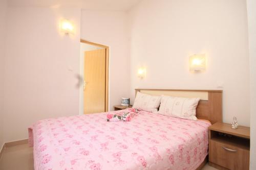 a bedroom with a pink bed with a pink blanket at Apartments by the sea Valun, Cres - 8086 in Valun