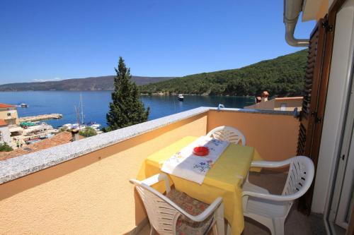 a table and chairs on a balcony with a view of the water at Apartments by the sea Valun, Cres - 8086 in Valun