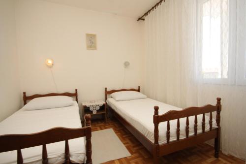 a bedroom with two beds and a window at Apartment Verunic 8104a in Veli Rat