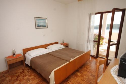 Žman的住宿－Twin Room Luka 8132e，一间带大床的卧室和一个阳台