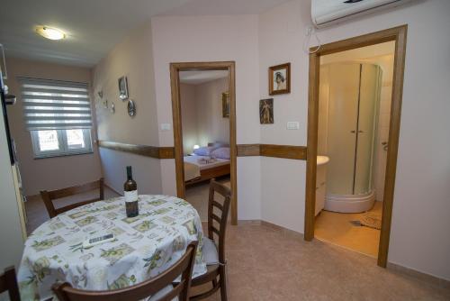 ein Esszimmer mit einem Tisch und einer Flasche Wein darauf in der Unterkunft Apartments with a parking space Punta kriza, Cres - 8082 in Punta Križa