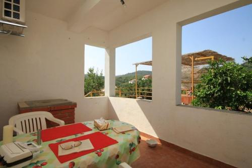 ein weißes Zimmer mit einem Tisch und einem großen Fenster in der Unterkunft Apartments by the sea Zaglav, Dugi otok - 8134 in Sali