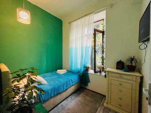 ein Schlafzimmer mit einem blauen Bett und einem Fenster in der Unterkunft kessane in Achalziche