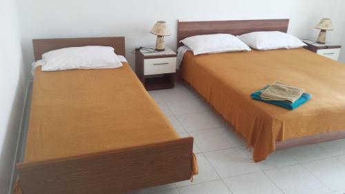 two beds sitting next to each other in a room at Apartment Savar 8079c in Brbinj