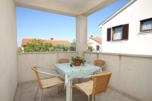 una mesa y sillas en un balcón con vistas en Apartments with a parking space Mali Losinj (Losinj) - 8090 en Mali Lošinj
