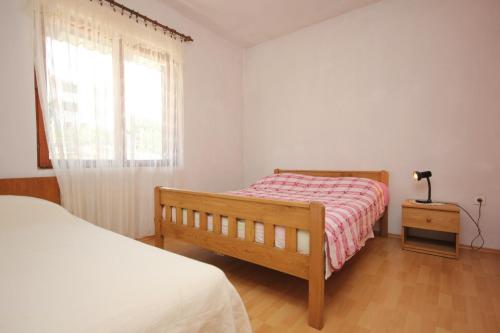 a bedroom with a bed and a window at Apartments by the sea Sali, Dugi otok - 8121 in Sali
