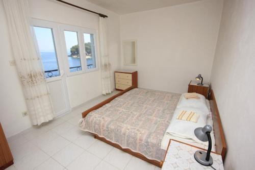 a bedroom with a bed and a large window at Apartments by the sea Savar, Dugi otok - 8079 in Brbinj