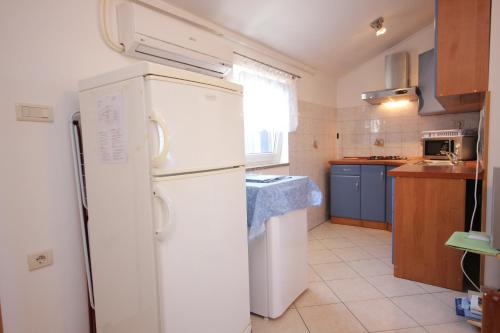 a kitchen with a white refrigerator and a sink at Apartments with WiFi Ilovik, Losinj - 8078 in Ilovik