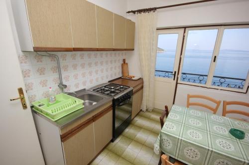 Brbinj的住宿－Apartment Savar 8079a，厨房配有水槽、炉灶和窗户。