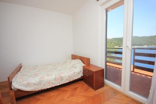 a bedroom with a bed and a large window at Apartments by the sea Savar, Dugi otok - 8080 in Brbinj