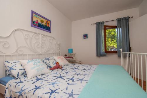 a bedroom with a bed with blue and white sheets at Apartment Mali Losinj 8093b in Mali Lošinj