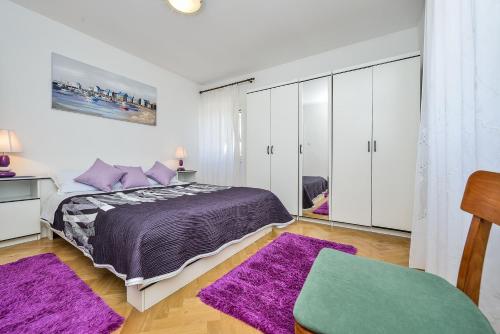 a bedroom with a purple bed and purple rugs at Holiday house with a parking space Veli Rat, Dugi otok - 8096 in Veli Rat