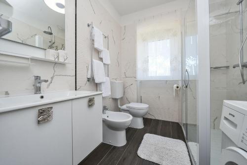 a white bathroom with a toilet and a sink at Holiday house with a parking space Veli Rat, Dugi otok - 8096 in Veli Rat