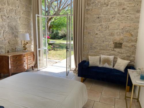een slaapkamer met een bed en een stenen muur bij Jas de Berrias Chambre d’hôte in Berrias Et Casteljau