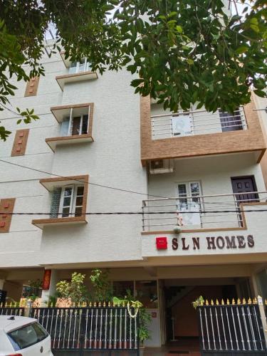 un edificio con un cartello che legge "Sun Homes" di HOTEL SLN Homes a Bangalore