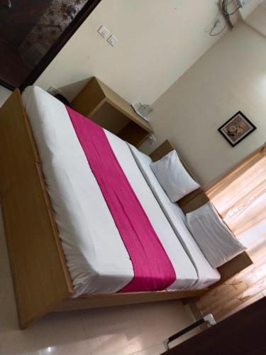 a large bed with a pink and white blanket on it at HOTEL SLN Homes in Bangalore
