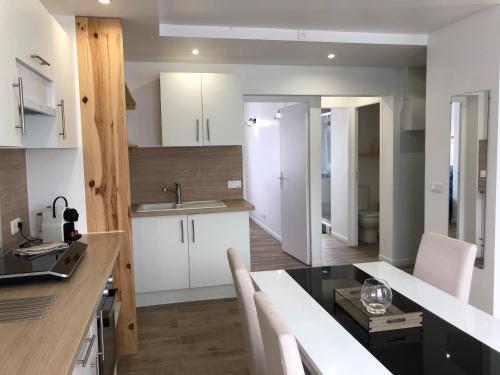 a kitchen with white cabinets and a counter top at AlloAppartMeuble StPol in Saint-Pol-sur-Ternoise